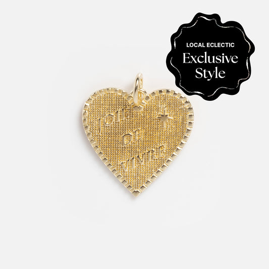 Yellow gold-filled heart-shaped pendant with a textured surface, engraved with JOIE DE VIVRE and a small cross, from the Zahava x Local Eclectic Globetrotter Charms collection.