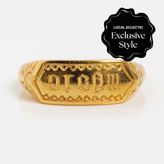 The Hunt of Hounds x Local Eclectic Dream/Magic Ring is an 18k gold vermeil ring with “dream” engraved backward on a rectangular face and a black corner badge that reads “Local Eclectic Exclusive Style.”.