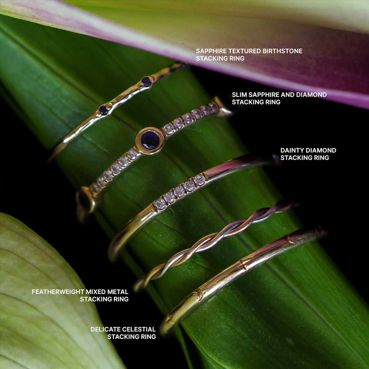 The Solid Gold Delicate Celestial Stacking Ring shines among five gold rings on a green stem, each showcasing unique designs—sapphire, diamond, twisted, mixed metal, and celestial styles for a stunning stacked look.
