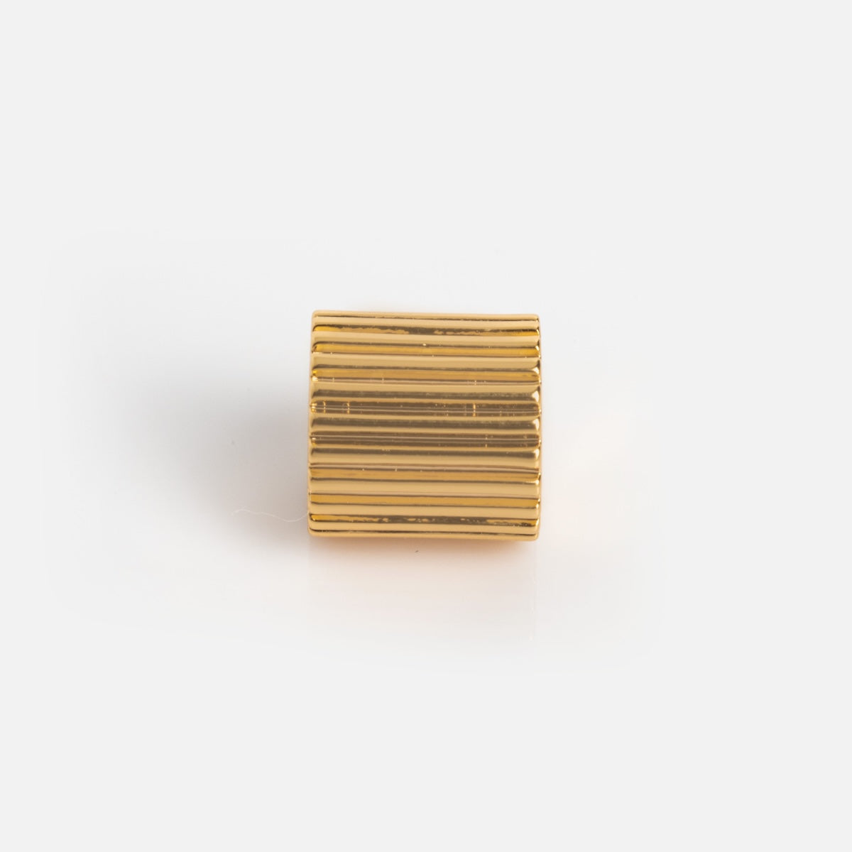 A small, cylindrical gold-plated Charms by Thatch charm with vertical ridges is displayed on a white surface against a plain white background.
