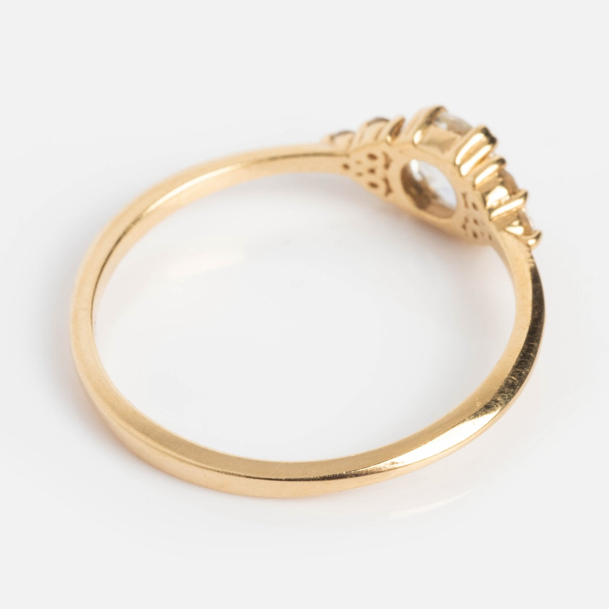 The Lune Ring with Rose Cut Diamond is a solid gold engagement ring with a thin band and a raised setting holding small diamonds, shown from the side on a white background.
