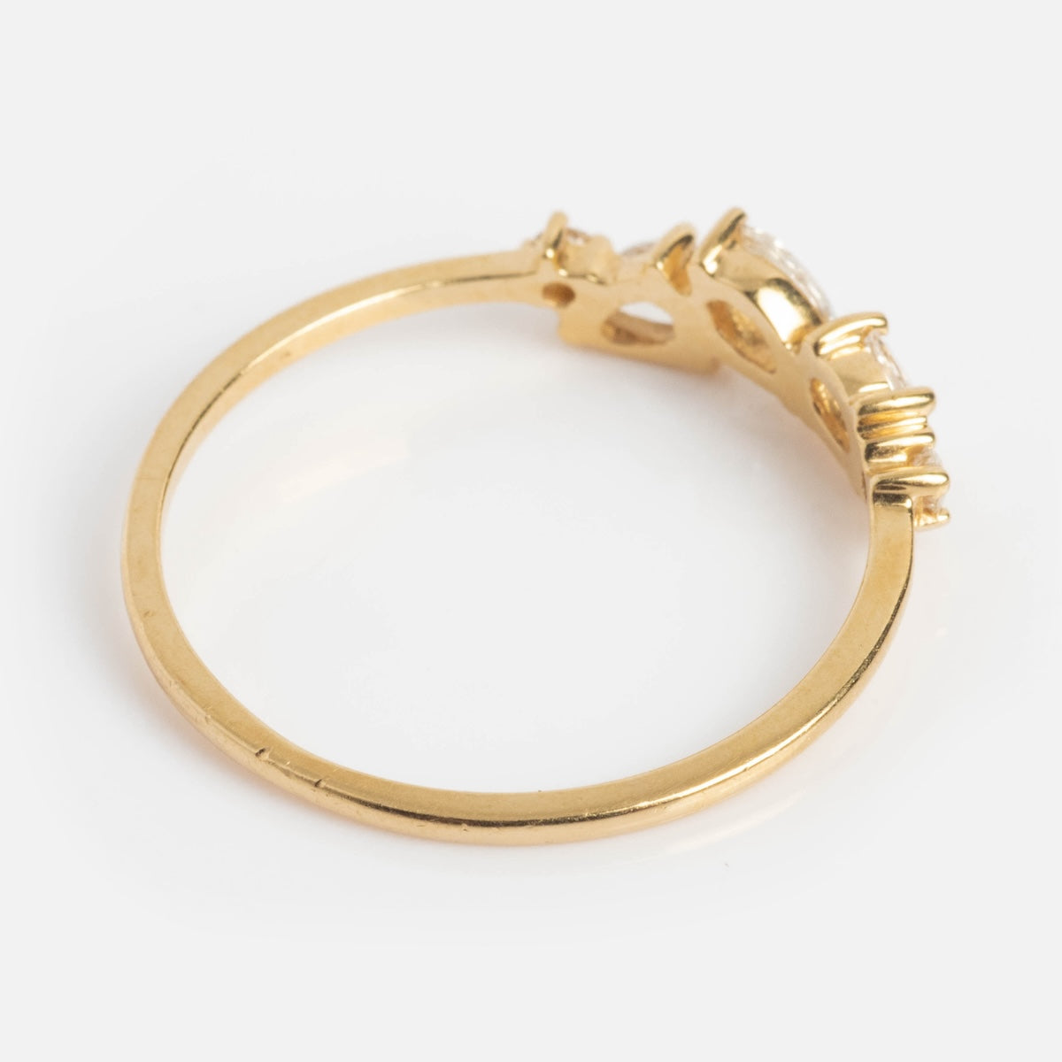 The Cosmos Ring is a slim 14k yellow gold band featuring a raised setting with several small rose-cut diamonds, shown from an angled side on a white background.