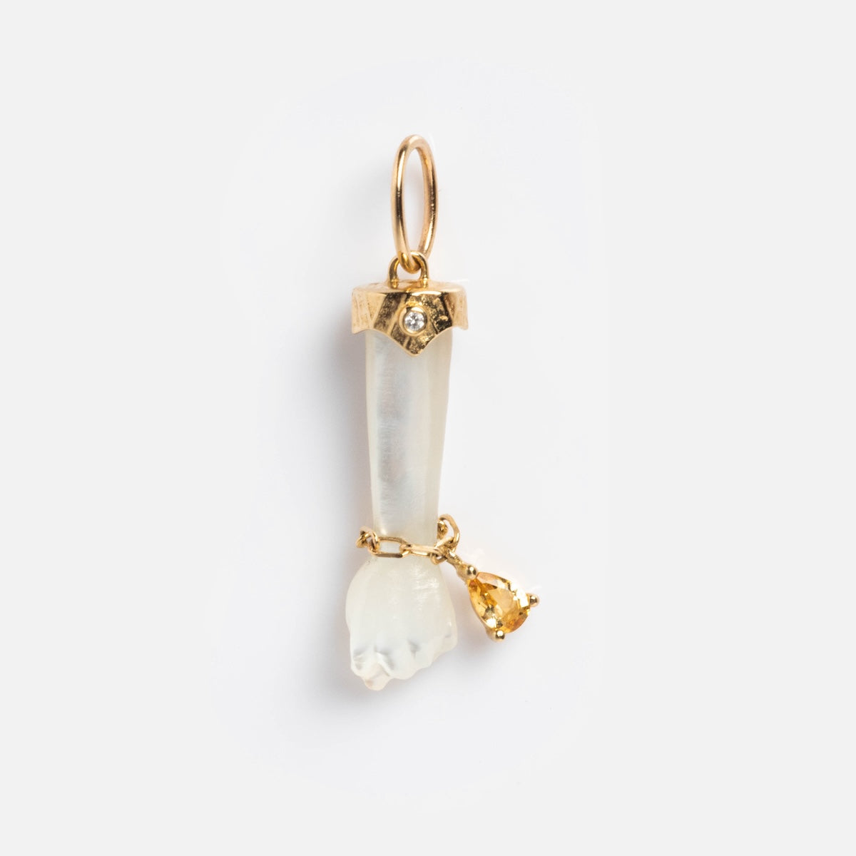 A Local Eclectic exclusive, the Solid Gold Body Language Charm is a pendant shaped like a small hand with a gold cuff and loop at the wrist, featuring a translucent design and adorned with a yellow gemstone.