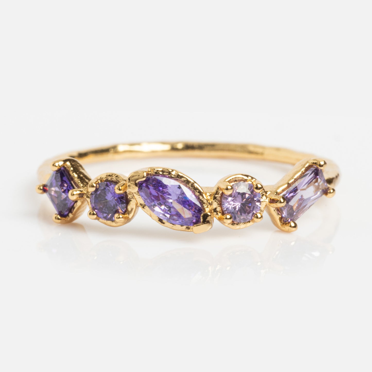 The Shades of You Ombre Birthstone Ring is a delicate 14k gold plated piece featuring five purple gemstones in various cuts, arranged in a row—an elegant birthstone jewelry accent.