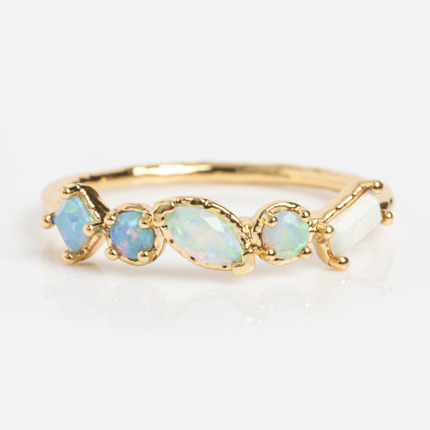 The Shades of You Ombre Birthstone Ring is a delicate 14k gold plated piece with five iridescent opal gemstones in different shapes and sizes, set in a row against a plain white background.