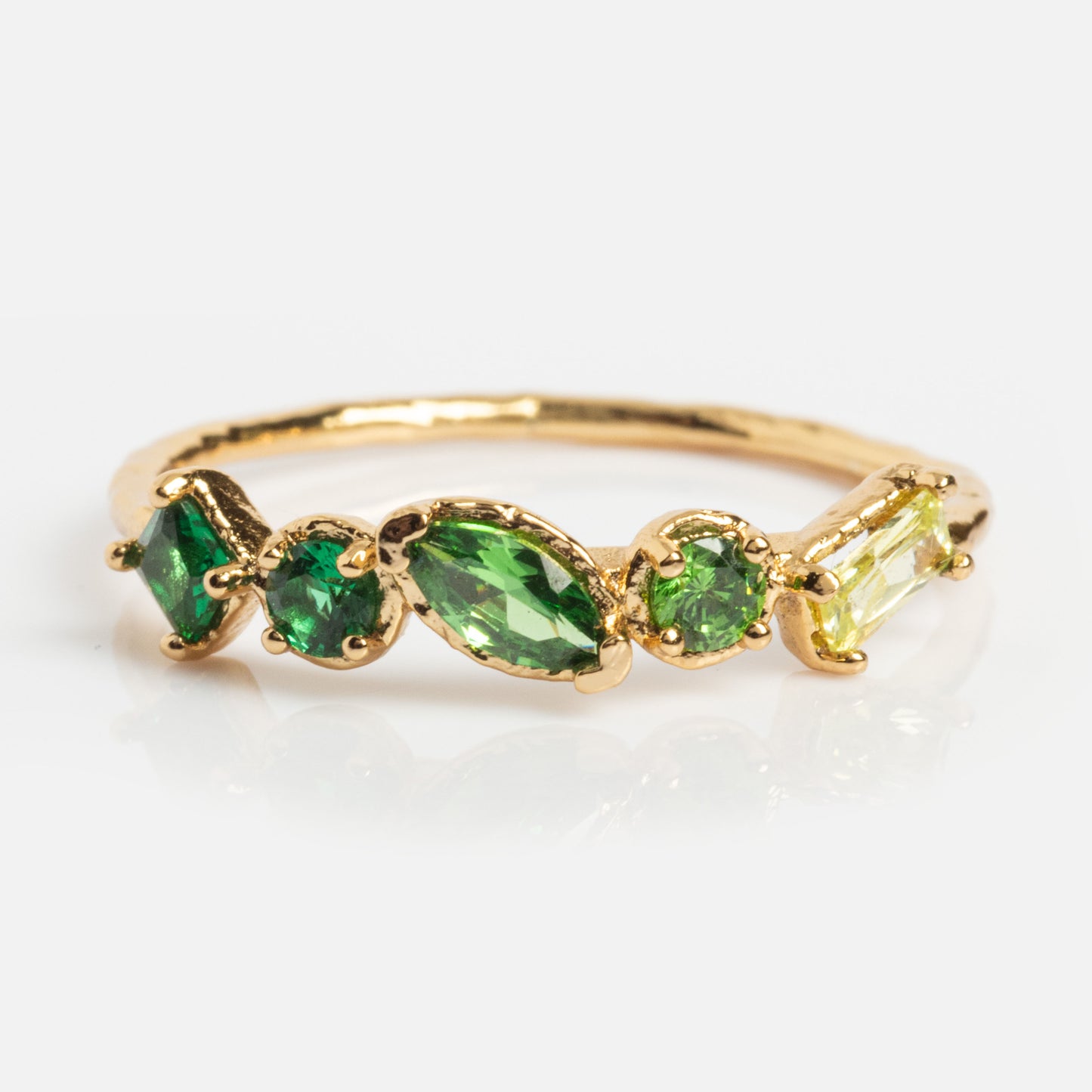 The Shades of You Ombre Birthstone Ring is a 14k gold plated piece with five assorted green and yellow gemstones in varied shapes set on a thin band, shown against a white background.