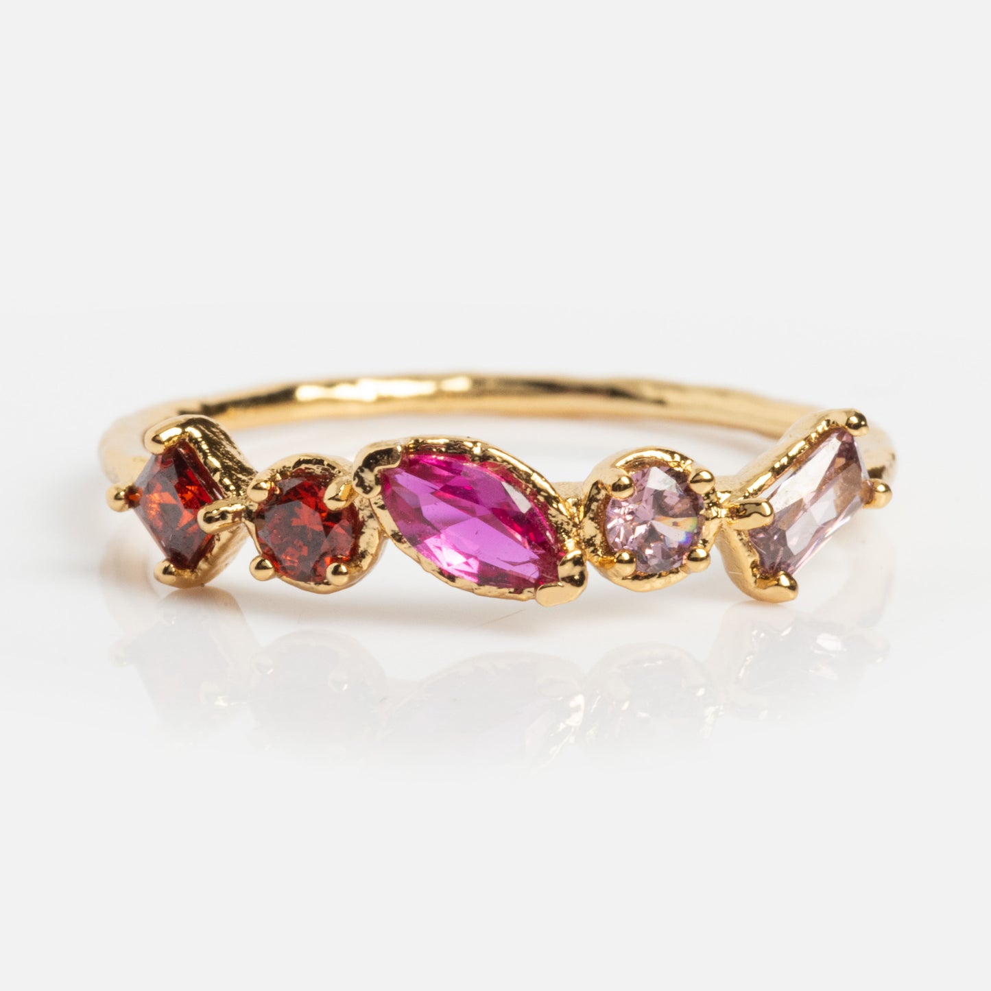 The Shades of You Ombre Birthstone Ring is 14k gold plated and features five gemstones in pink, red, and purple hues in varied shapes, elegantly arranged on a white background.