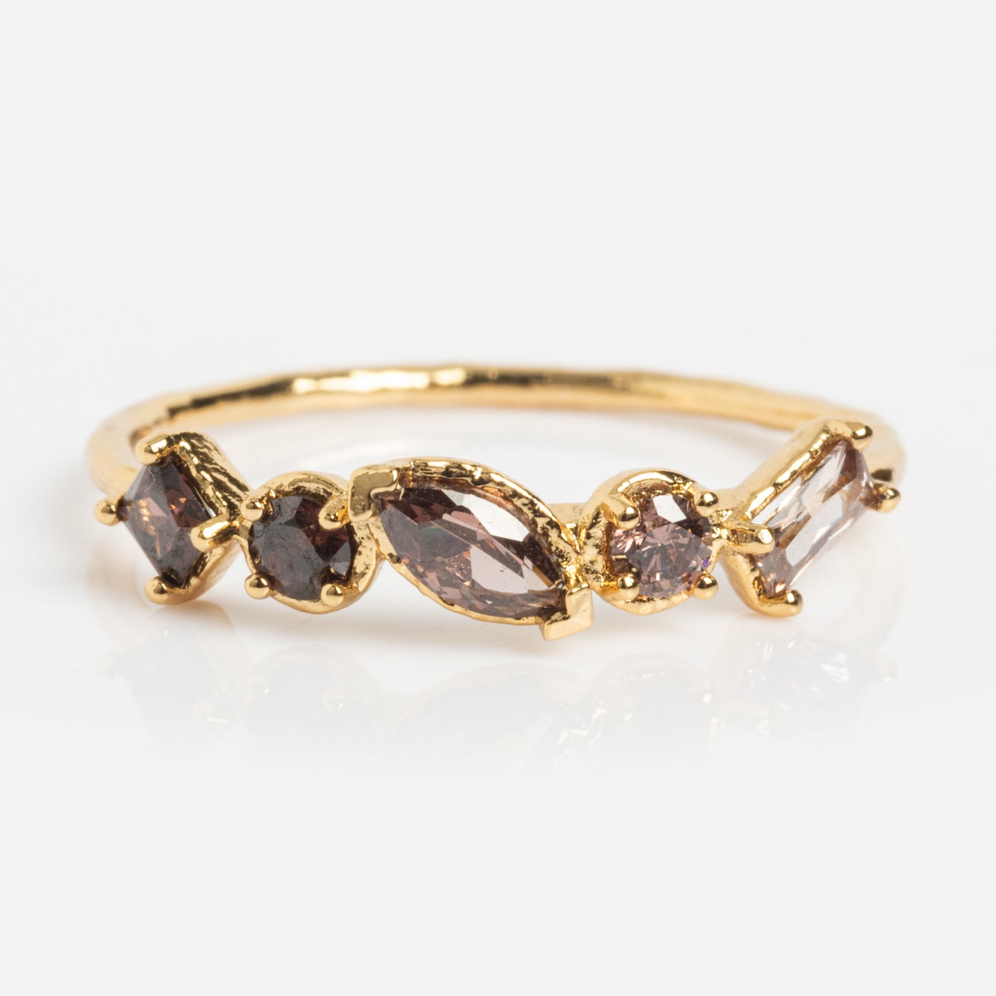 The Shades of You Ombre Birthstone Ring, plated in 14k gold, showcases five brown gemstones of assorted shapes and sizes set in a row on the band, displayed against a white background.
