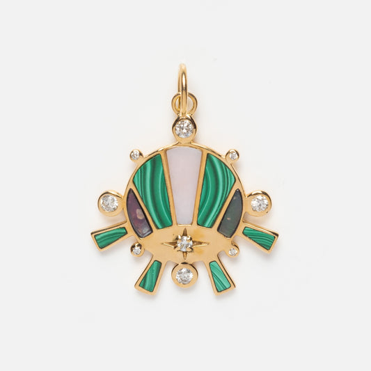 The Bioluminescent Charm is a solid gold necklace with green, pink, and black inlays and round diamonds at its center and edges, styled like an eye or sunburst, shown against a plain white background.