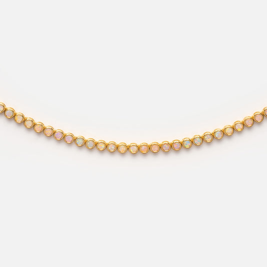 The Opal Ombre Tennis Necklace features round iridescent lab-created opals in 18k gold-plated bezels, elegantly arranged in a row and shown on a plain white background.