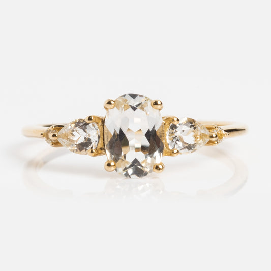 The Solid Gold 2025 April Capsule White Topaz Statement Set features a central oval-cut white topaz, April’s birthstone, with two round clear side stones on a simple solid gold band. Comes with a free gift.