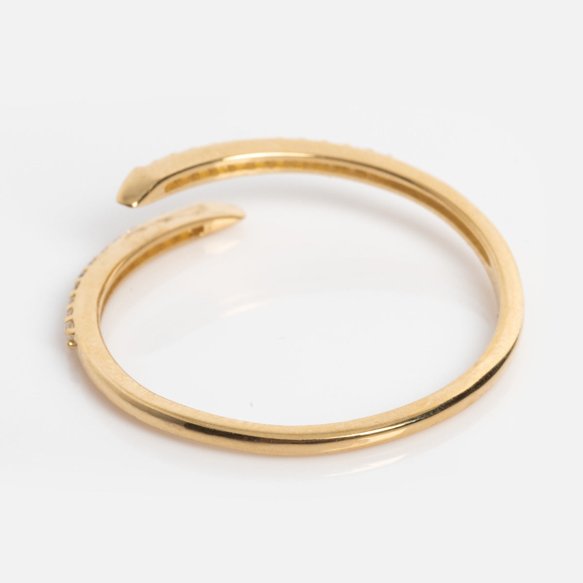 The Solid Gold 2025 April Capsule White Topaz Wrapped Stacking Ring is a minimalist, adjustable piece with tapered, open ends that gracefully curve but dont touch, shown on a white background.