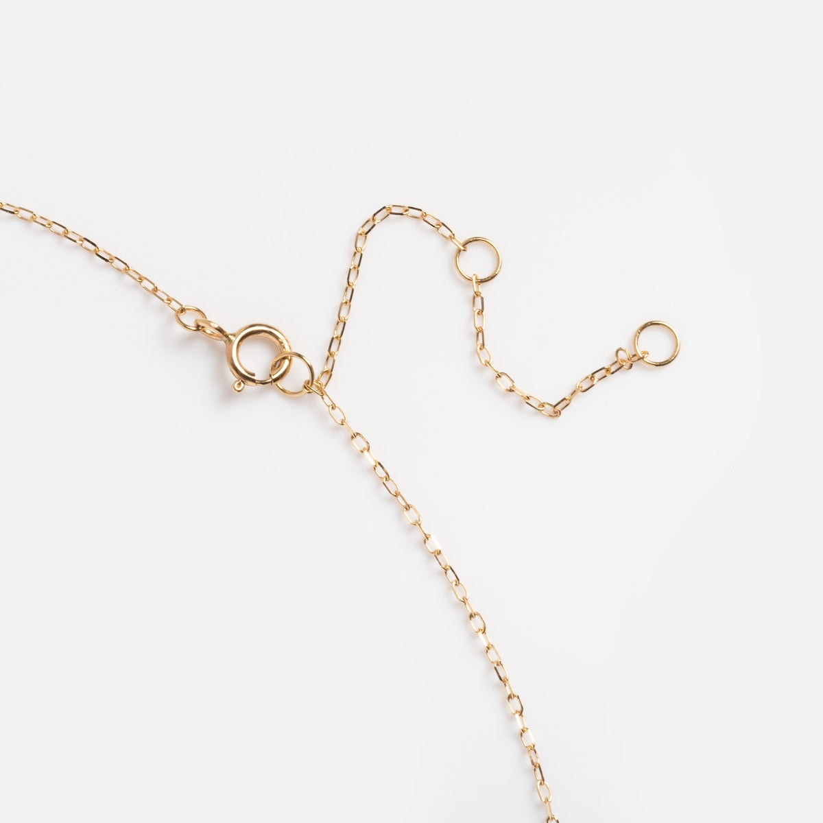 The Solid Gold 2025 April Capsule White Topaz Art Deco Pendant Necklace features a delicate design with a spring ring clasp and two extra jump rings for adjustable length, shown on a white background.