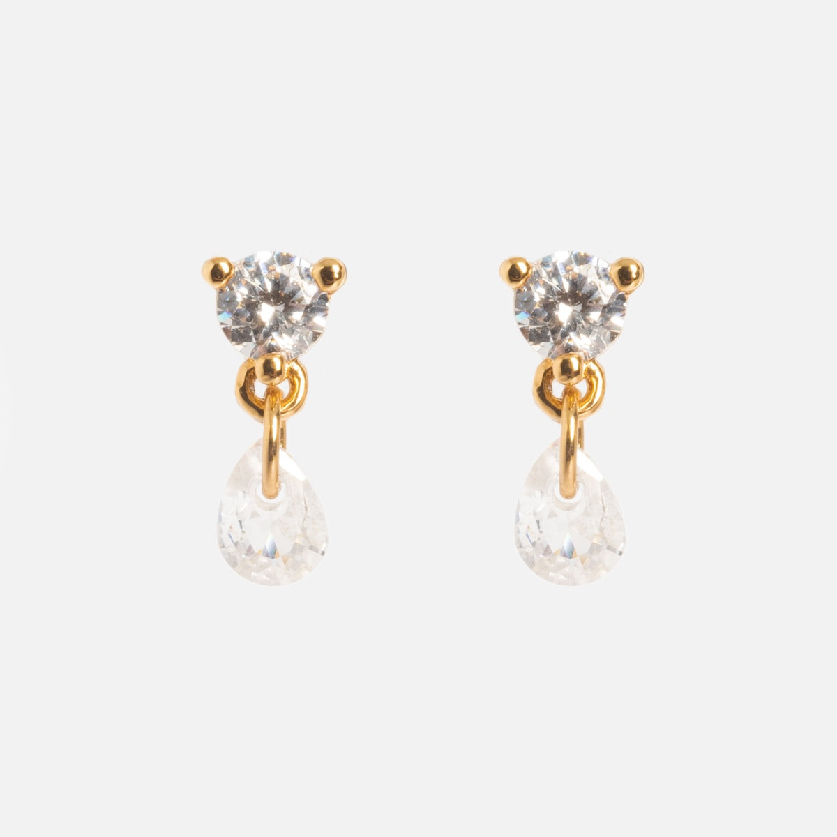 The Round CZ Stud with Floating Pear CZ Drop Sample features 18k yellow gold plated brass, a round clear gemstone stud, and a dangling teardrop-shaped CZ on a gold loop. Drop: 9 mm. Displayed on a plain white background.