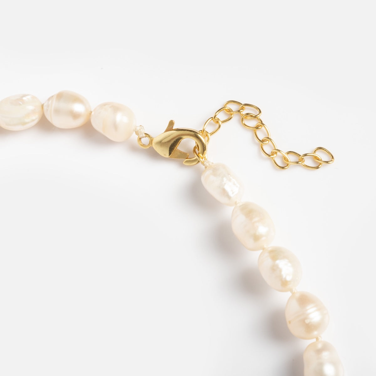 A close-up of the Freshwater Pearl Knotted Necklace, featuring an 18k gold plated chain extender and lobster clasp, set against a plain white background.