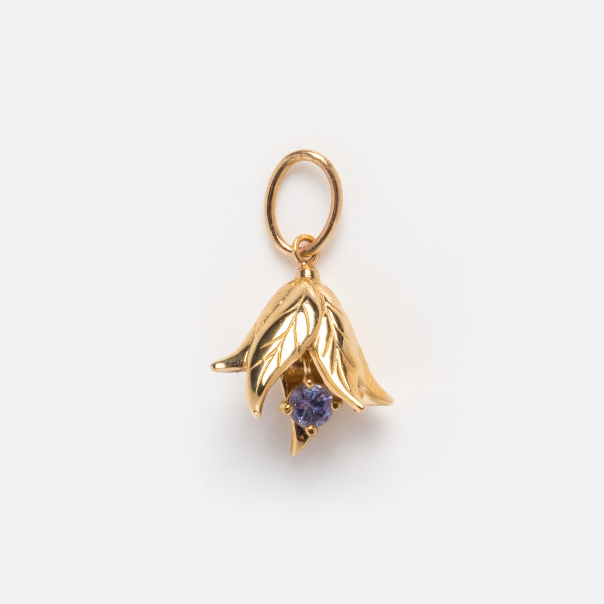 The Solid Gold Birth Flower Bud Charm features overlapping leaf shapes with a central purple gemstone and a round loop at the top, making it ideal for personalized jewelry lovers seeking unique birthstone pendants.