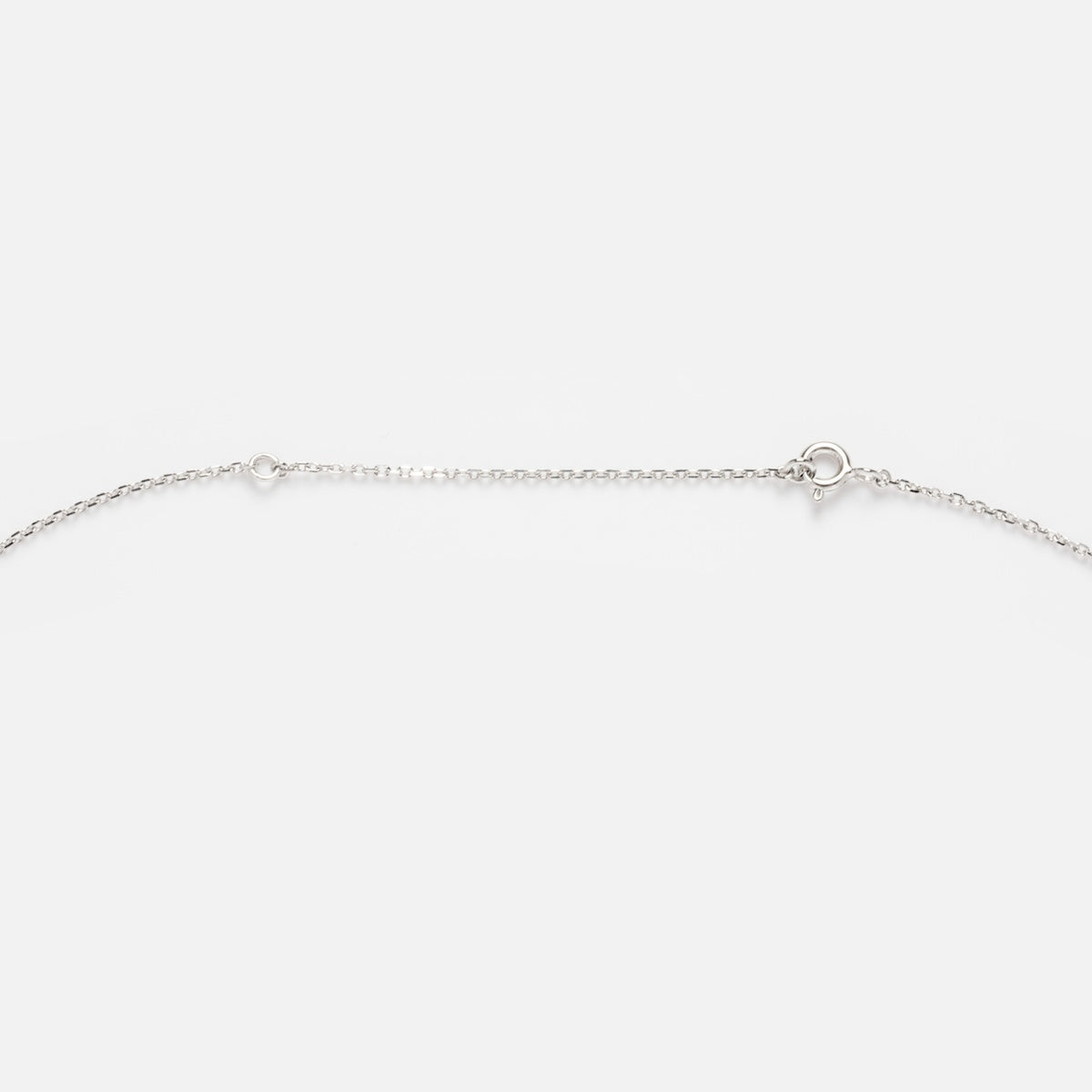 The Solid Gold Simple Glimmer Gold Chain is a delicate 9k gold necklace featuring a small round clasp at the center, shown against a plain white background.