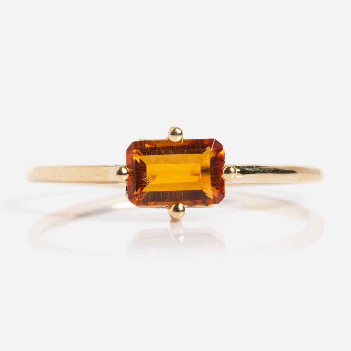 The 14k Mod Love Birthstone Ring showcases a rectangular, deep orange gemstone in a four-prong setting, displayed against a plain white background.