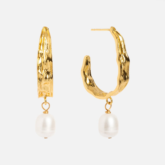 The Judy Pearl Statement Hoop Earrings feature textured gold organic hoops with dangling white pearls, offering a bohemian jewelry style. Shown against a white background.