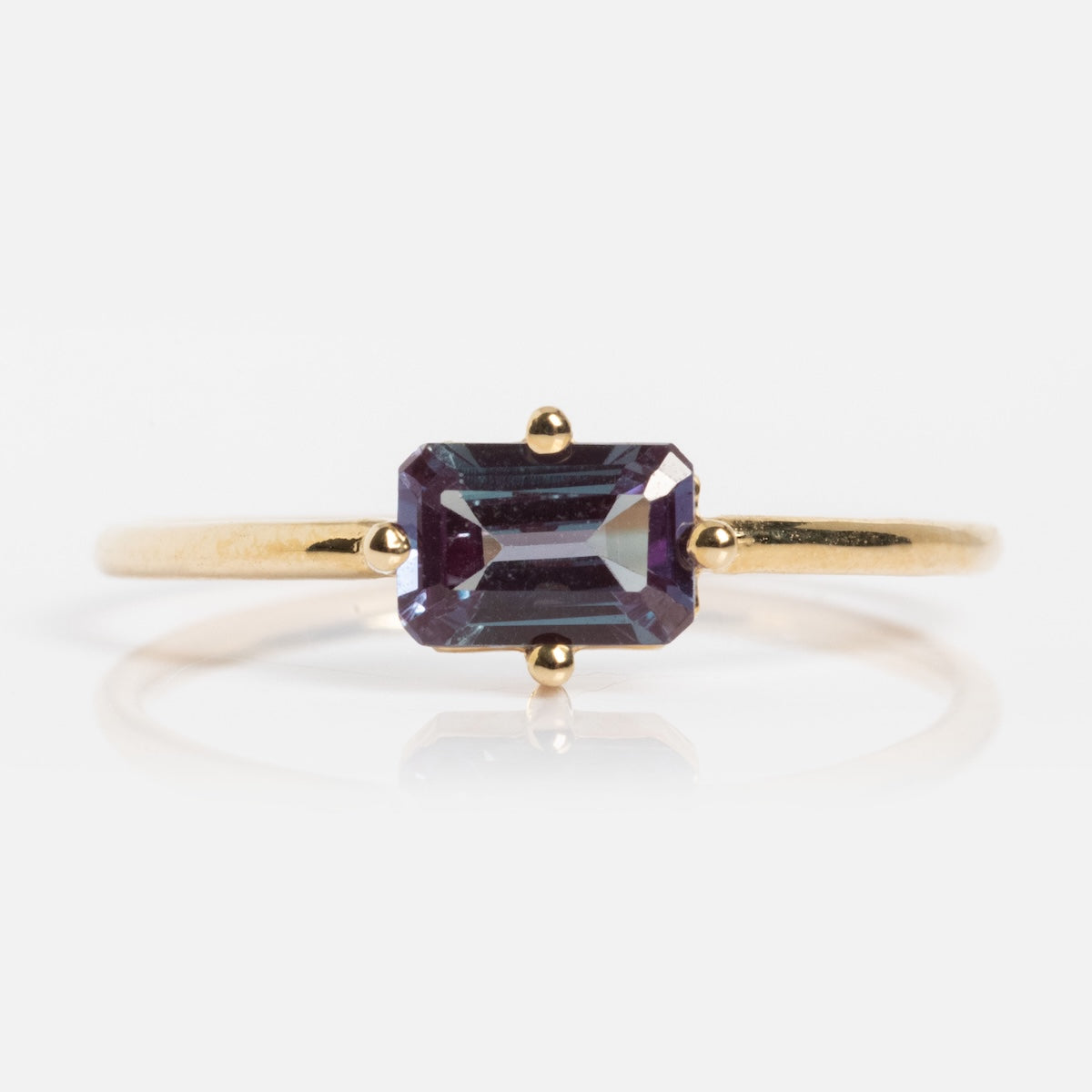 The 14k Mod Love Birthstone Ring features a rectangular emerald-cut purple gemstone set on a minimalist yellow gold band, shown against a white background.