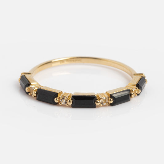 The Solid Gold Black Agate Baguette Band is a thin 9k yellow gold ring with rectangular black agate and small clear stones set in a row, shown against a white background.