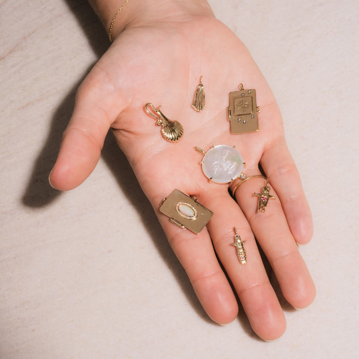 Seven Sofia Zakia charms laid on palm to show scale