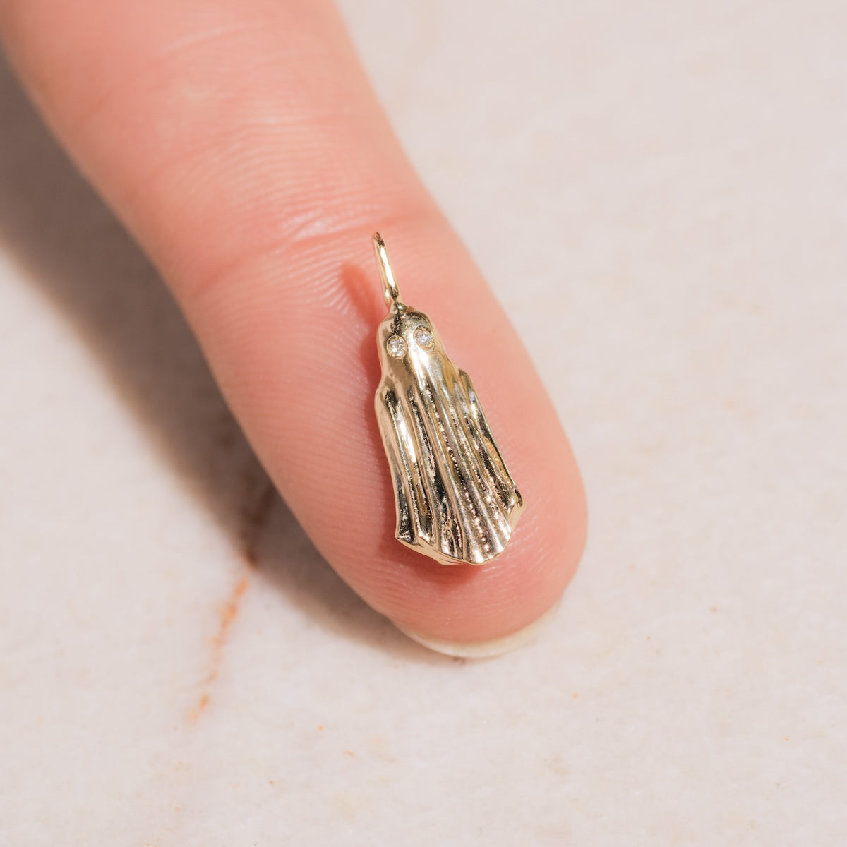Diamond Ghost Charm laid on fingertip