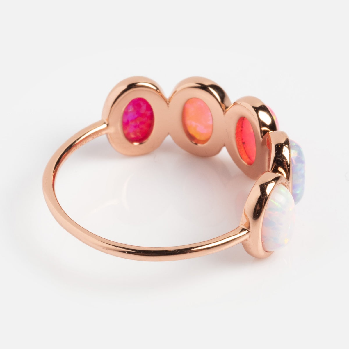 The Rose Gold Opal Ombre Candy Band showcases five oval opals in pink, orange, and white hues, set in a row on a simple rose gold vermeil band, displayed against a white background.