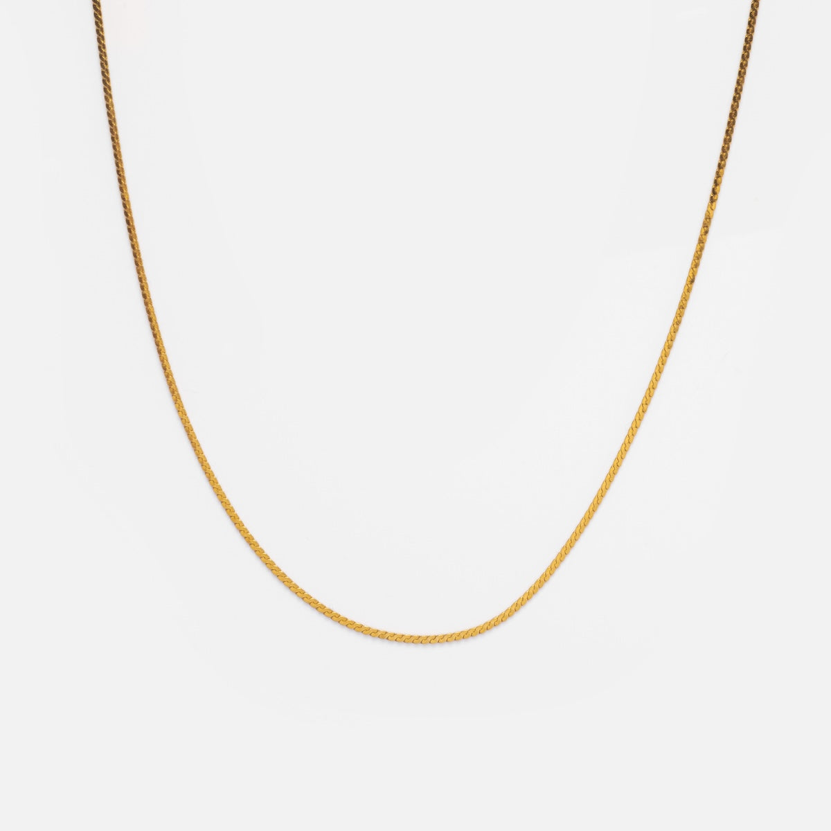 The Vermeil S Chain, a delicate gold vermeil necklace, is elegantly displayed against a plain white background.