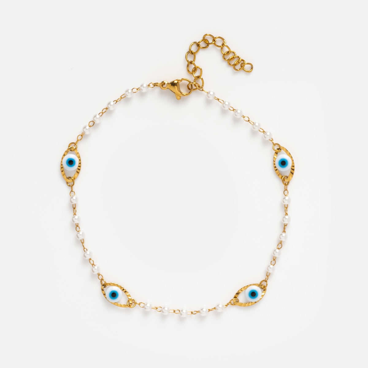 The Evil Eye Anklet features gold plating, small white beads, and four blue evil eye charms evenly spaced on the chain. With an adjustable clasp, this delicate anklet is perfect for those who love subtle evil eye jewelry.