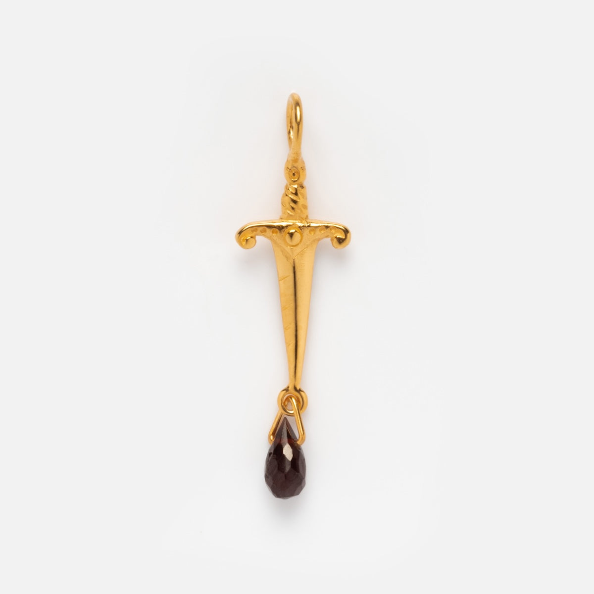 The Charms by Hunt of Hounds features a gold vermeil dagger-shaped pendant with a detailed hilt and a dark teardrop gemstone hanging from the tip, displayed on a plain white background—a bold addition to any jewelry collection.