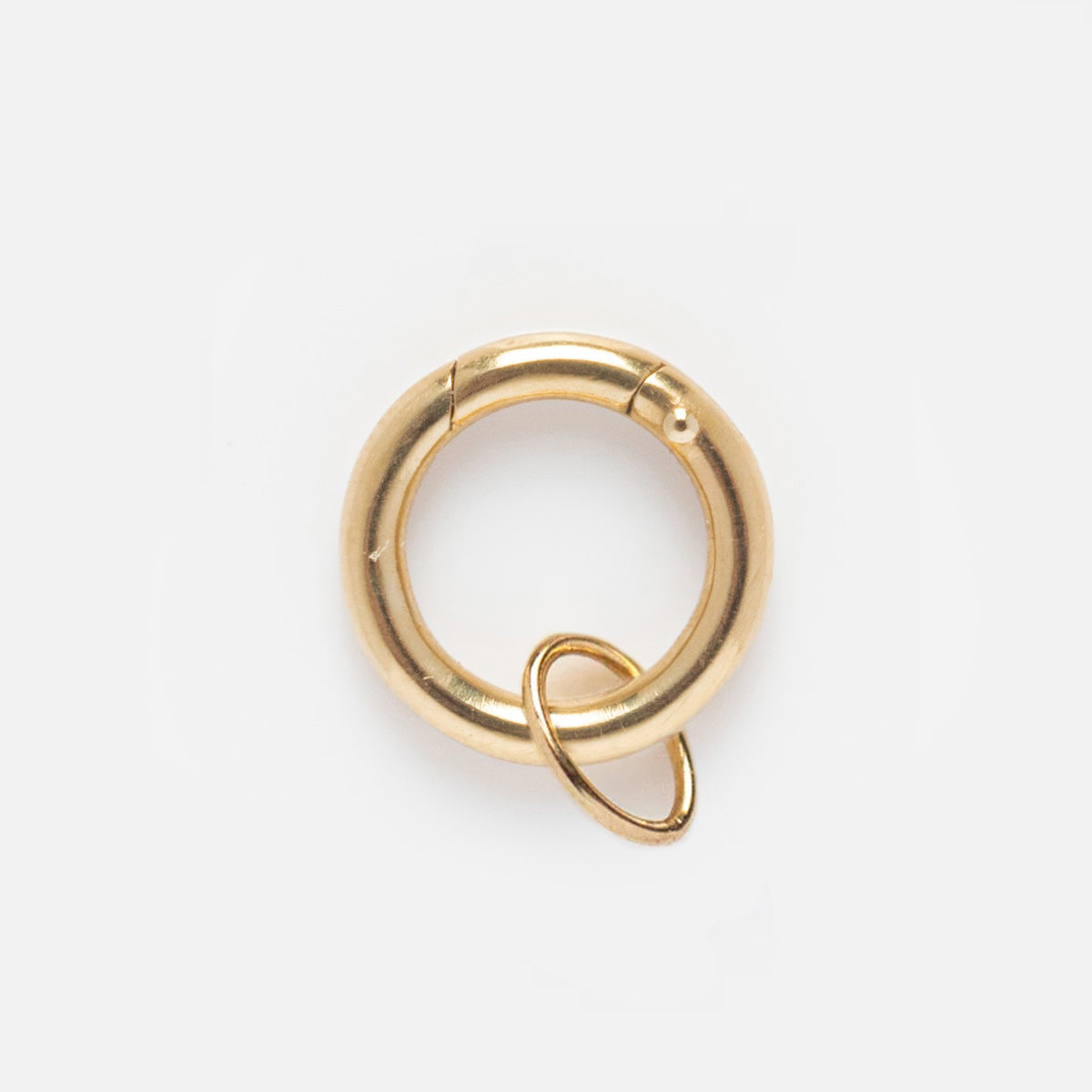 The Solid Gold Charm Clip is a small, circular gold spring ring clasp, ideal for attaching bracelets or connecting jewelry pieces, displayed on a plain white background.
