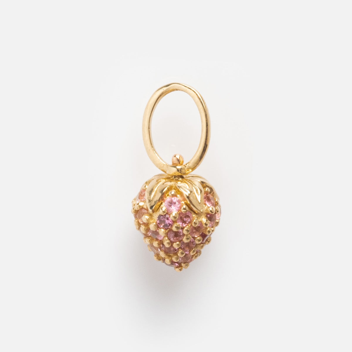 The Solid Gold Foodie Charm is a petite 9k yellow gold strawberry-shaped charm, adorned with pink gemstones and a gold leaf top—ideal for a fruit-themed necklace and shown on a plain white background.