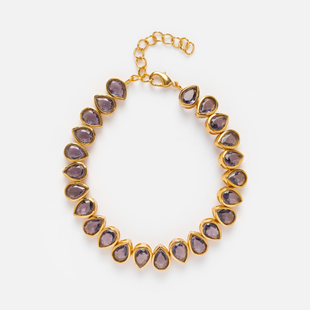 The Bezel Set Birthstone Tennis Bracelet features sparkling gemstones in gold bezels, with an adjustable clasp and extender chain—perfect for pairing with gold necklaces for a coordinated, elegant look.