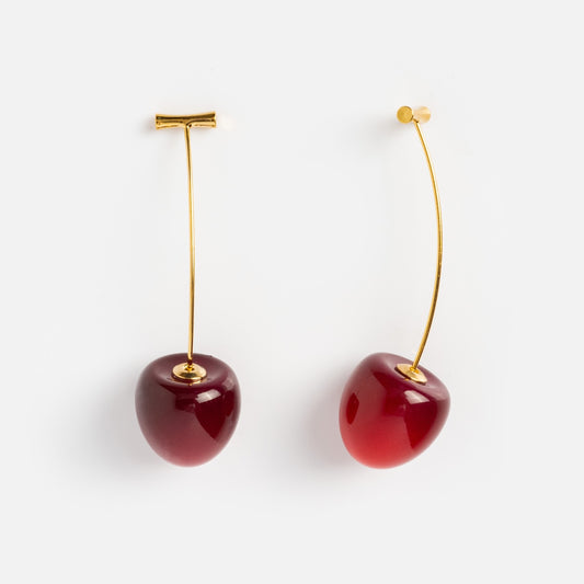 The Cherry and Stem Earrings feature yellow gold plated curved stems and glossy dark red cherry-shaped pendants, shown against a plain white background.