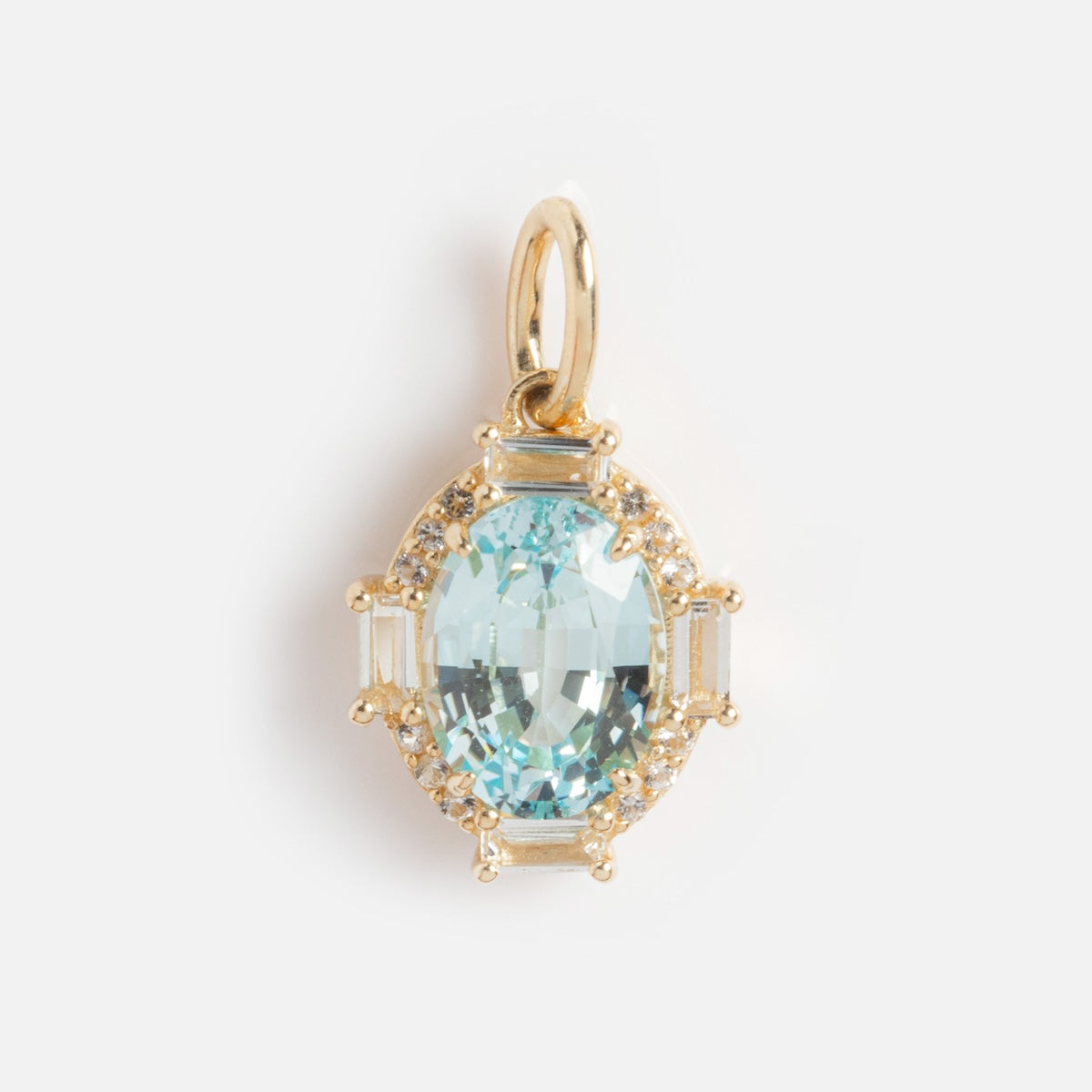 The Solid Gold Vintage Inspired Birthstone Charm features an oval aquamarine gemstone set in a gold frame with small round and rectangular accent stones, plus a gold loop for easy attachment—timeless elegance on a white background.
