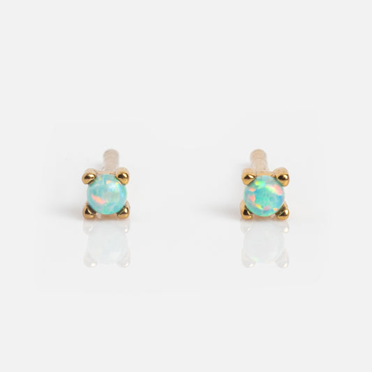 Fabulous Studs: 14k gold plated stud earrings with round opal gemstones secured by four prongs, shown on a white background with a subtle reflection.