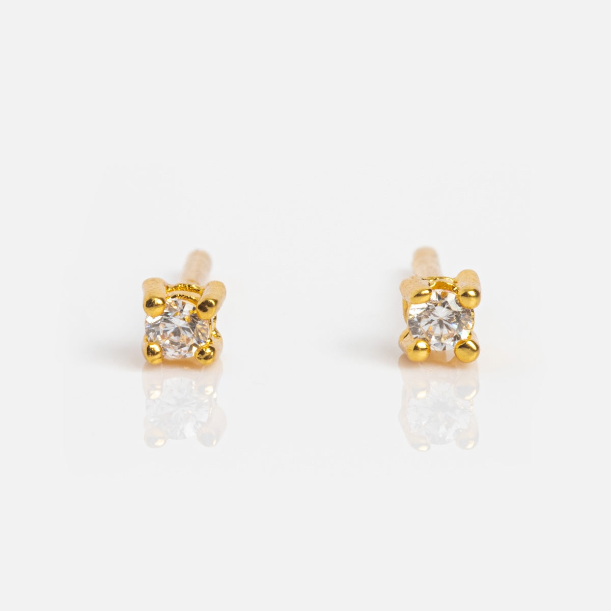 Fabulous Studs are small 14k gold plated earrings, each set with a single round clear gemstone in a four-prong setting, shown on a white background.