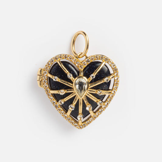 The Solid Gold Changeable Crystal Locket Charm for Manifestation features a heart-shaped design with a dark glittery center, teardrop gem, and radiant gold lines with stone accents. Includes a loop—perfect for your favorite chain or as crystal jewelry.