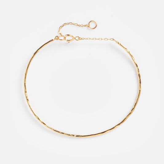 The Solid Gold Structured Bracelet, crafted in 9k solid gold, features a thin, textured design with a delicate adjustable chain and lobster clasp, displayed on a plain white background.