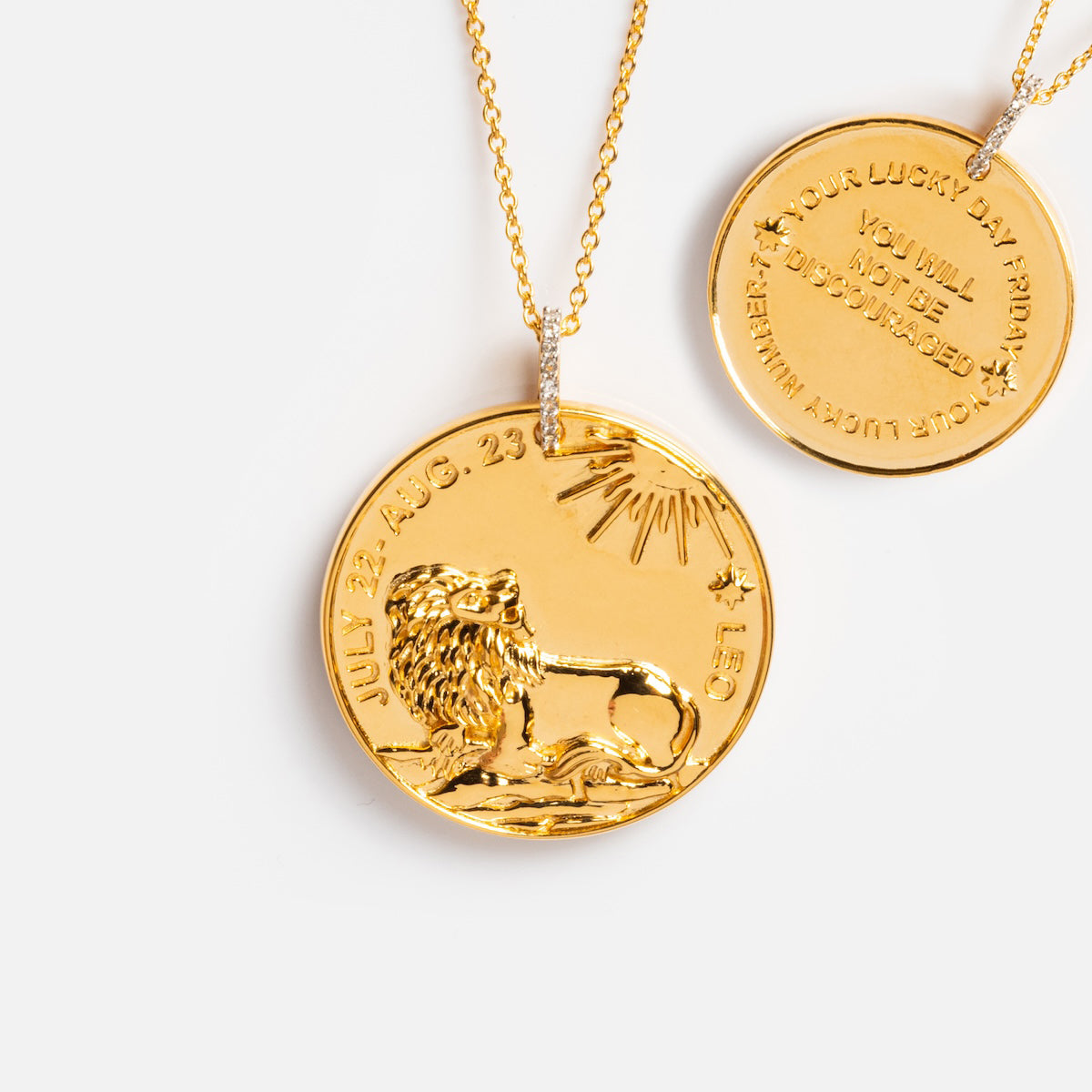Two gold vermeil necklaces on delicate chains: the Vintage Inspired Zodiac Coin Necklace features a lion and LEO dates, while the other displays engraved text; both styles are shown against a white background.