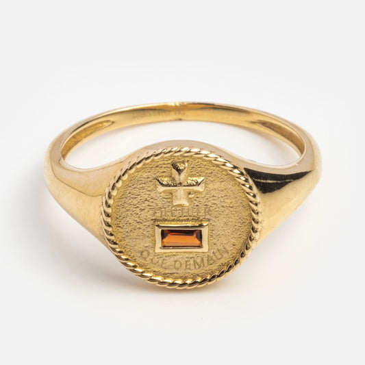 The Solid Gold Quhier Que Demain Signet Ring features a textured round face with an engraved bird above a rectangular amber gemstone and the inscription Quhier Que Demain below the gem.