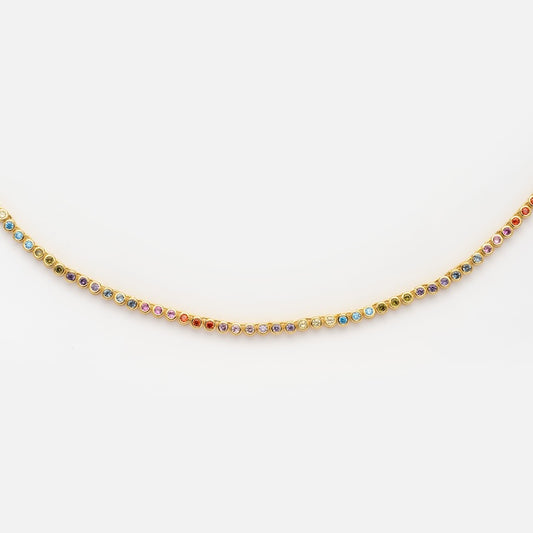 The Dreamworks Tennis Necklace features an 18k gold-plated chain accented with evenly spaced, small round simulated colored diamonds, shown against a plain white background.