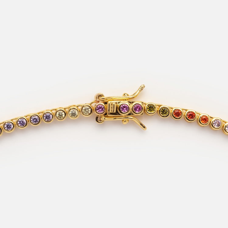 The Dreamworks Tennis Necklace features simulated colored diamonds—purple, green, red, orange, and yellow—in a repeating pattern, elegantly finished with an 18k gold plated shine.
