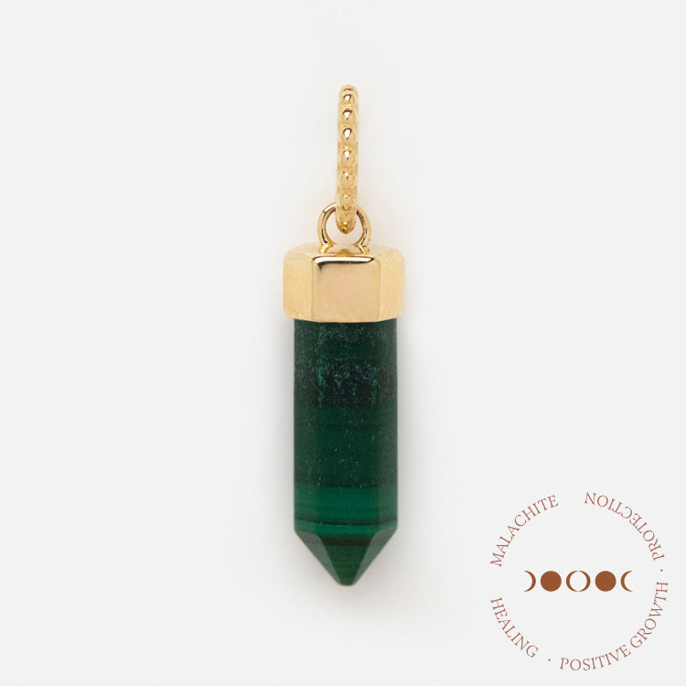 A Solid Gold Crystal Charm for Manifestation, featuring a gold-capped green malachite pendant with a dotted gold loop, is displayed on a white background. A brown emblem in the corner reads Malachite, Protection, Positive Growth, Healing.