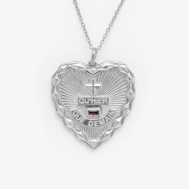 The Quhier Que Demain Heart Pendant Necklace showcases a romantic silver heart design with French love symbolism, highlighted against a plain white background.