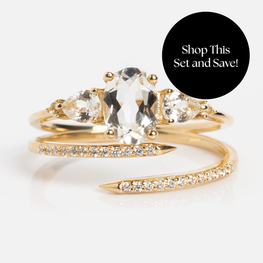 Shop the Solid Gold 2025 April Capsule White Topaz Ring Set—featuring an oval white topaz centerpiece, two pear-shaped side stones, and a diamond-accented wrap band—and get a free gift!.