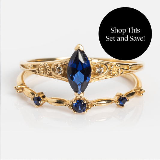 The Solid Gold 2025 September Capsule Blue Sapphire Ring Set features two stacked gold rings: one with a marquise-cut blue sapphire and the other with small blue sapphires. Exclusive to Local Eclectic. Shop this set and receive a free gift!.