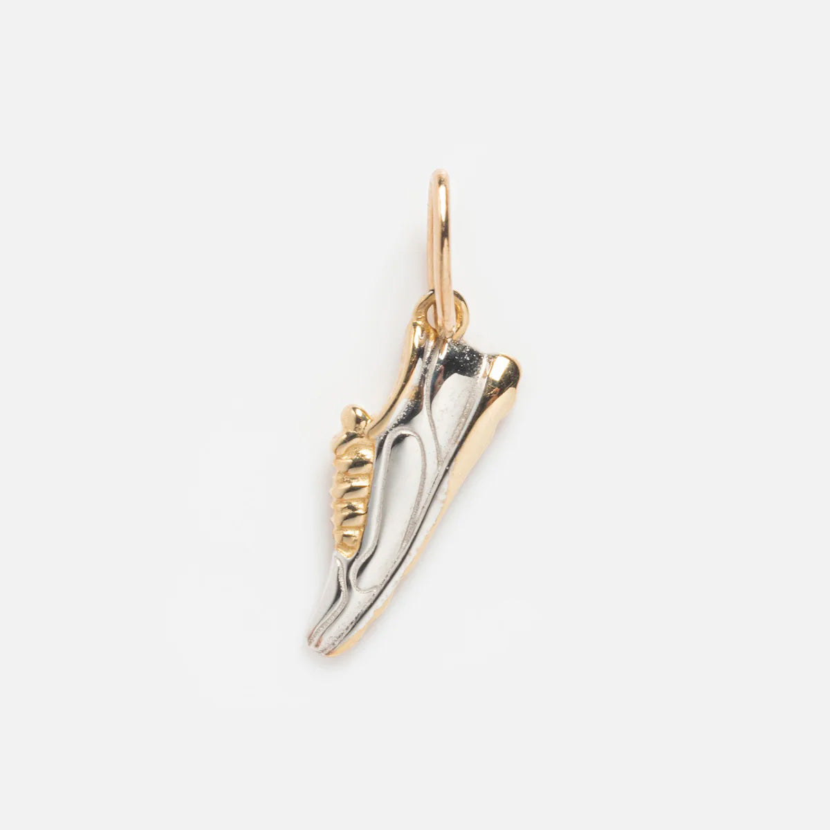 The Solid Gold Celebration Charm is a small sneaker-shaped charm with a gold loop, featuring a two-tone silver and 9k solid yellow gold design, shown on a light gray background.