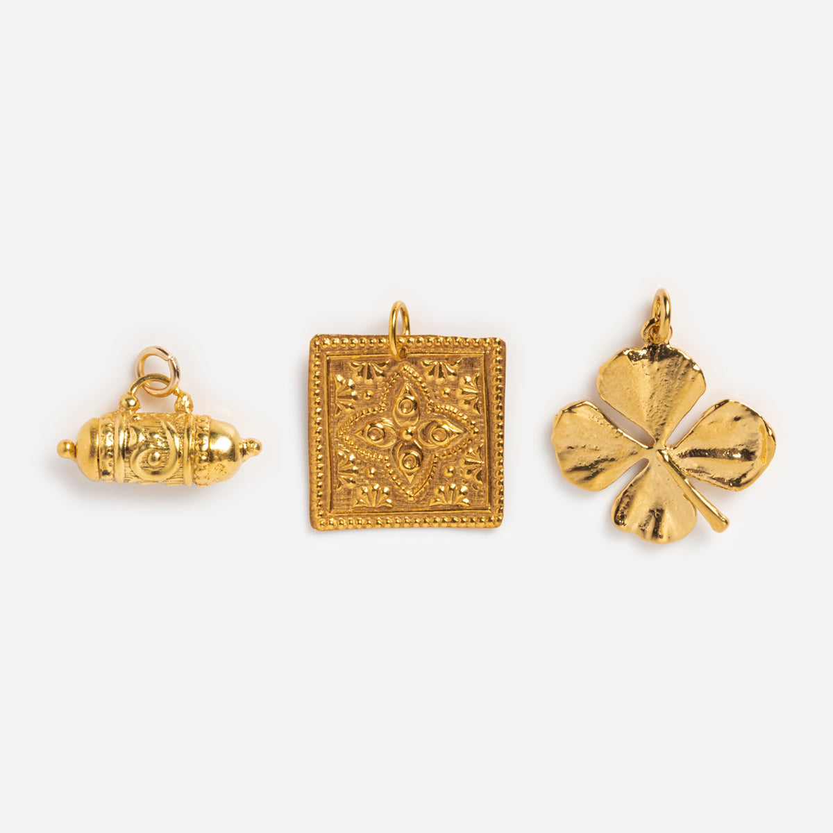 Tum, Kinara, and four leaf clover charm on white background